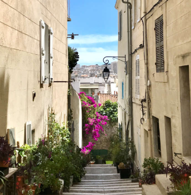 Senior actif profitant d’une promenade en bord de mer dans le Sud de la France, sous un ciel ensoleillé, illustrant la douceur de vivre et le climat méditerranéen.