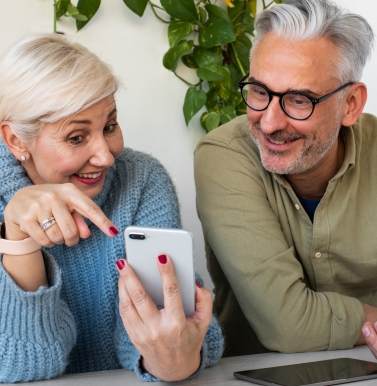 Groupe de jeunes retraités partageant un salon lumineux dans un coliving, discutant autour d’une table, illustrant la convivialité et l’autonomie de ce mode de vie.